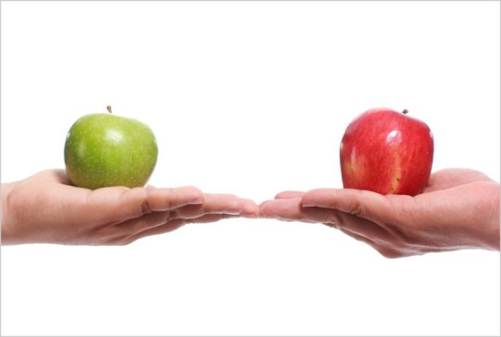 One hand holding green apple next to another hand holding red apple.